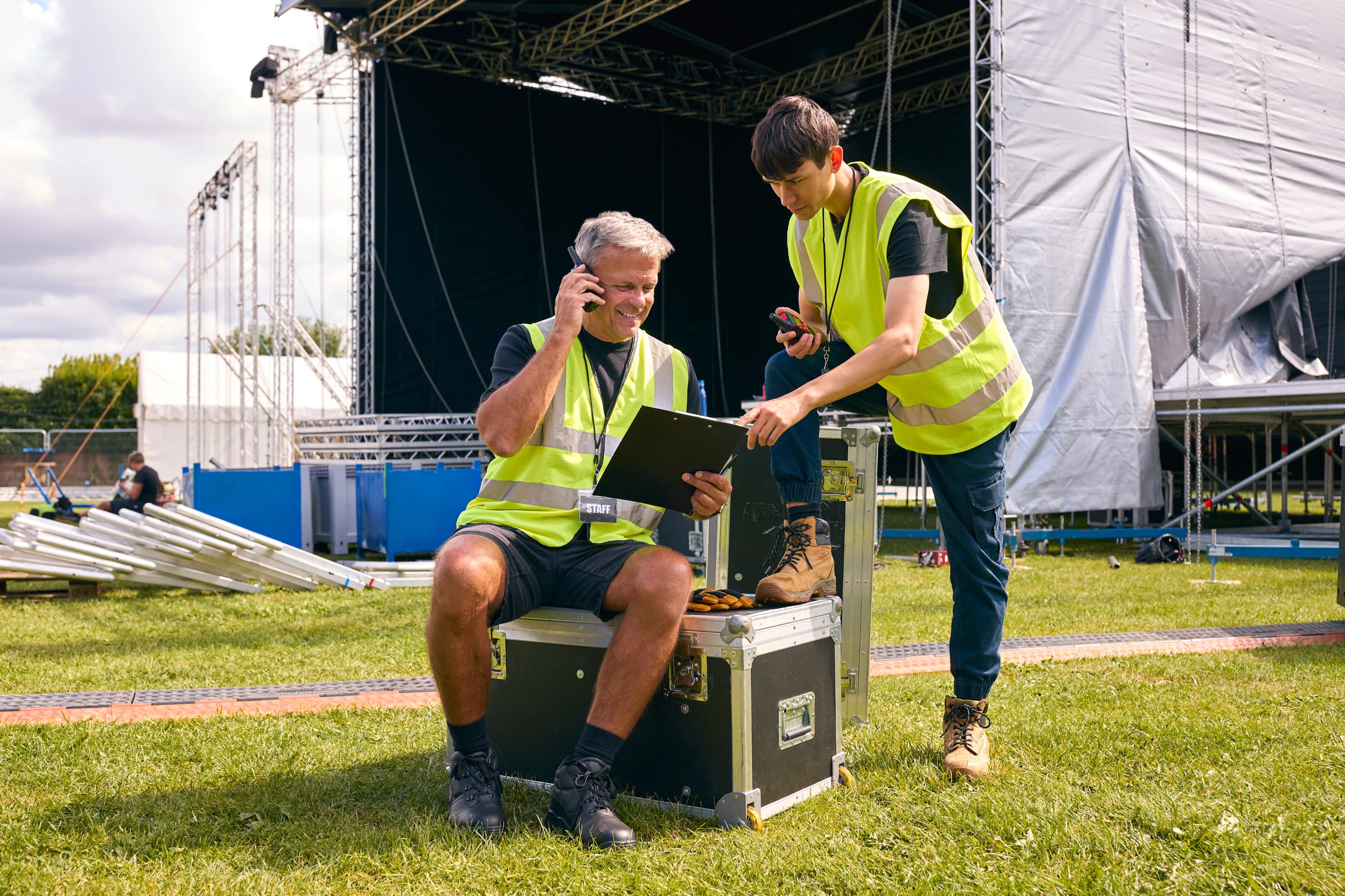 Stage crew members setting up event equipment and lighting