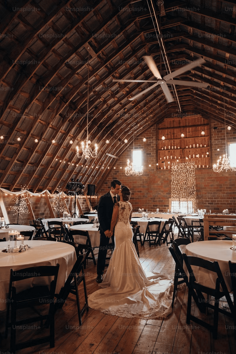Bride and groom celebrating in a decorated rustic barn wedding reception
